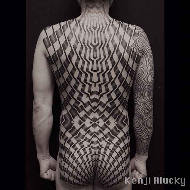 Geometric tattoo sleeve design on a man’s arm while driving a car