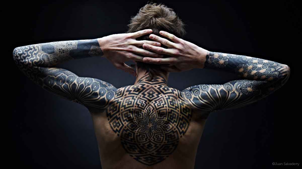 A tattoo model posing with detailed back tattoos