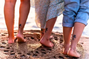 Matching small ankle tattoo design for couples on the beach
