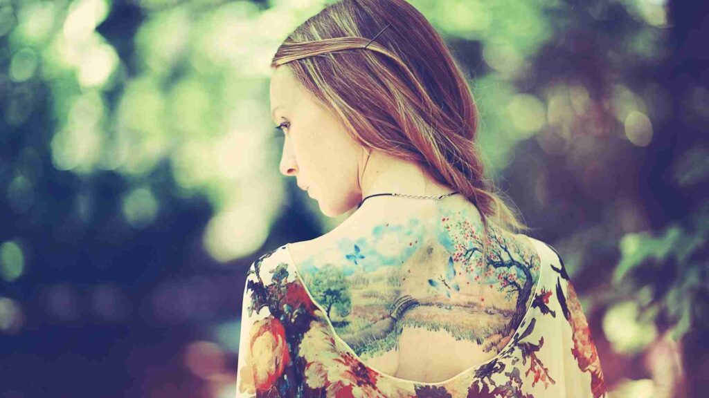 A tattoo model posing with detailed back tattoos